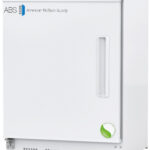 A white laboratory refrigerator by American BioTech Supply with a digital temperature display, a rectangular handle, a lock on top, and a green leaf sticker at the bottom right corner of the door. The ABS logo appears on the upper left.