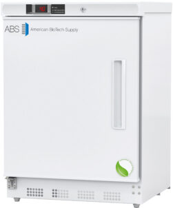 A white laboratory refrigerator by American BioTech Supply with a digital temperature display, a rectangular handle, a lock on top, and a green leaf sticker at the bottom right corner of the door. The ABS logo appears on the upper left.