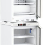 Two white, under-counter laboratory refrigerators with doors open. The top fridge contains shelves, a small fan on the back wall, and a blue-capped bottle inside. The bottom fridge is empty with three shelves. Both have digital control panels above the door.
