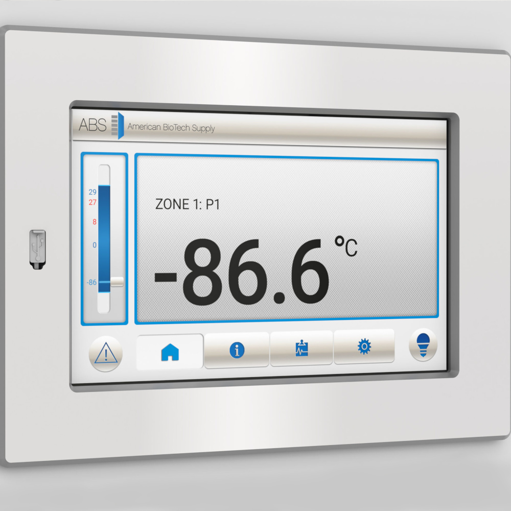 A digital control panel from American BioTech Supply displays “ZONE 1: P1” and a temperature reading of -86.6°C. The screen includes icons along the bottom for alerts, home, settings, and information. The panel is set in a silver frame.