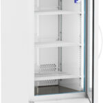 A tall, white medical refrigerator with a transparent glass door is open, revealing three empty wire shelves inside. The digital display on top shows a temperature of 4.0°C. The unit is on wheels and labeled “ABS” in the upper left corner.