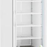 A tall, white laboratory refrigerator with a glass door, five adjustable wire shelves, a digital temperature display at the top, ventilation at the bottom, and wheels for mobility. The interior appears empty and clean, with a blue label inside.