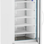A white laboratory refrigerator with a glass door is open, revealing five empty wire shelves. The digital temperature display above the door reads 4.0°C. The unit is on wheels and has a storage drawer at the bottom. One blue vial sits on the top shelf.