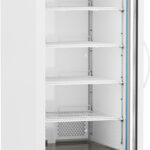 A tall, white, upright laboratory refrigerator with a glass door is shown open. The interior has multiple adjustable wire shelves, a digital temperature display at the top, and wheels at the base for mobility. The unit is clean and empty.