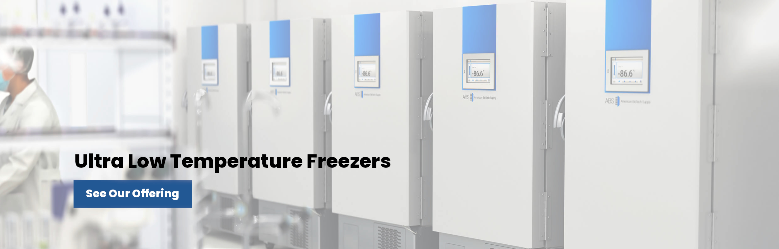 Row of large white ultra-low temperature freezers with digital displays in a clean laboratory setting; a person in lab attire stands blurred in the background. Bold text reads “Ultra Low Temperature Freezers” and a blue button says “See Our Offering.”