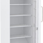 A white, upright refrigerator with its door open, showing four empty metal shelves and a plain door interior with a handle. A digital control panel is visible at the bottom front of the fridge. The interior is clean and well-lit.