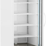 A tall, white, commercial refrigerator with a glass door is pictured. It has five empty wire shelves, a digital temperature display at the top, vented panels at the bottom, and is mounted on wheels for mobility. The door is partly open, revealing the interior.