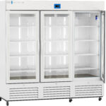 A large, white, three-door laboratory refrigerator with glass doors, interior shelves, and a digital temperature display on top. The brand logo ABS appears on the upper left. The unit has lower ventilation grills and caster wheels for mobility.