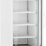 A tall, white laboratory refrigerator with a glass front door stands open, revealing five empty metal shelves inside. The unit has a digital temperature display on top, vents at the bottom, wheels, and the ABS logo on the upper left corner.
