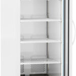 A tall, white, single-door commercial refrigerator with a glass front, digital temperature display, five wire shelves, and wheels on the bottom. The interior is empty, and the door is open, showing the shelving and a lit interior.