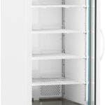 A tall, white laboratory refrigerator with a glass door ajar, five adjustable wire shelves, a digital temperature display at the top, and ventilation grilles at the bottom. The fridge is on wheels and has a handle on the door’s right side.