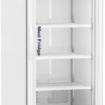 A tall, white, single-door medical refrigerator with a glass front displays five empty wire shelves. The digital temperature display above the door shows 2.0°C. The fridge stands on four small wheels and has ventilation slots at the bottom.