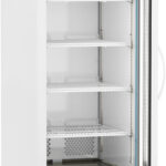 A tall, white laboratory refrigerator with a glass door, four adjustable wire shelves, a digital temperature display at the top, ventilation holes in the back, and wheels at the base. The interior appears well-lit and clean.
