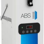 A white and blue rectangular medical or laboratory device labeled ABS with a black digital control panel featuring buttons and a red LED display. The unit has a handle on the side and a black latch on top, standing on four small feet.