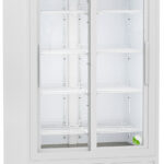 A tall, white commercial refrigerator with sliding glass doors, five adjustable wire shelves, an electronic control panel at the top, and ventilation grilles at the bottom. The interior is lit, and the exterior has casters for mobility.