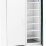 A tall white laboratory refrigerator with two doors: one solid, one glass. The glass door is open, showing multiple empty white wire shelves inside. The front panel displays a digital temperature readout. The unit is on wheels.