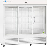 A large, white commercial refrigerator with three sliding glass doors, empty shelves inside, a digital temperature display on top, and a small green and white item in the lower right corner. The words Med Fridge appear on the middle door.