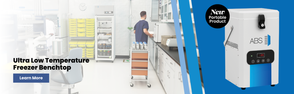 A lab technician stands in a bright laboratory near shelves and equipment. On the right, a portable ABS Ultra Low Temperature Freezer Benchtop offers advanced cold storage solutions, featuring digital controls, a lock, and a “New Portable Product” badge.
