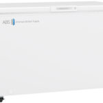Large white chest freezer on wheels with a closed lid. The front displays ABS American BioTech Supply, a green eco-friendly logo, and a small digital temperature display showing -20. The overall design is clean and industrial, suitable for laboratory use.