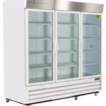 A large, white commercial refrigerator with three clear glass doors, vertical handles, metal trim, and interior shelves. The refrigerator is empty and on wheels, with ventilation grilles at the bottom and a logo on the top left corner.