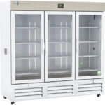 A large, white, three-door laboratory refrigerator with glass doors and metal shelves. The digital temperature display is above the center door. Shelves inside are empty, and interior LED lights illuminate the unit. Vents are located along the bottom front.
