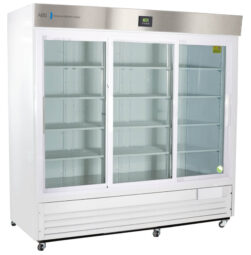 A large, commercial, white refrigerator with three glass sliding doors and multiple empty shelves inside. The top has a stainless steel panel with a digital temperature display. The unit stands on small legs and appears clean and modern.