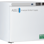 A white American BioTech Supply ABS freezer with a digital display showing -20°C, a control panel, and eco-friendly labels on the lower right. The ABS logo and company name are on the door. The unit is compact with a flat top and simple design.