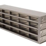 A rectangular metal storage unit with three rows and five columns of open compartments, totaling fifteen slots. Three drawers with label holders are stacked vertically on the right side. The surface is smooth and metallic gray.