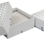 Three white cardboard freezer storage boxes with grids for organizing small lab tubes or vials, each box has a removable lid labeled with coordinates letters and numbers for sample identification; one box is open showing the interior grid.