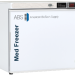 A white solid door vaccine medical freezer labeled Med Freezer and American BioTech Supply with a digital display showing -20°C. There’s a circular green and blue NSF/ANSI 456 certification mark on the lower right corner of the door.