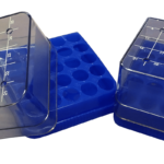 Three blue plastic laboratory tube racks with transparent, squared lids marked with numbered grids from 1 to 25. The racks have circular slots for holding test tubes and are shown at various angles on a plain white background.